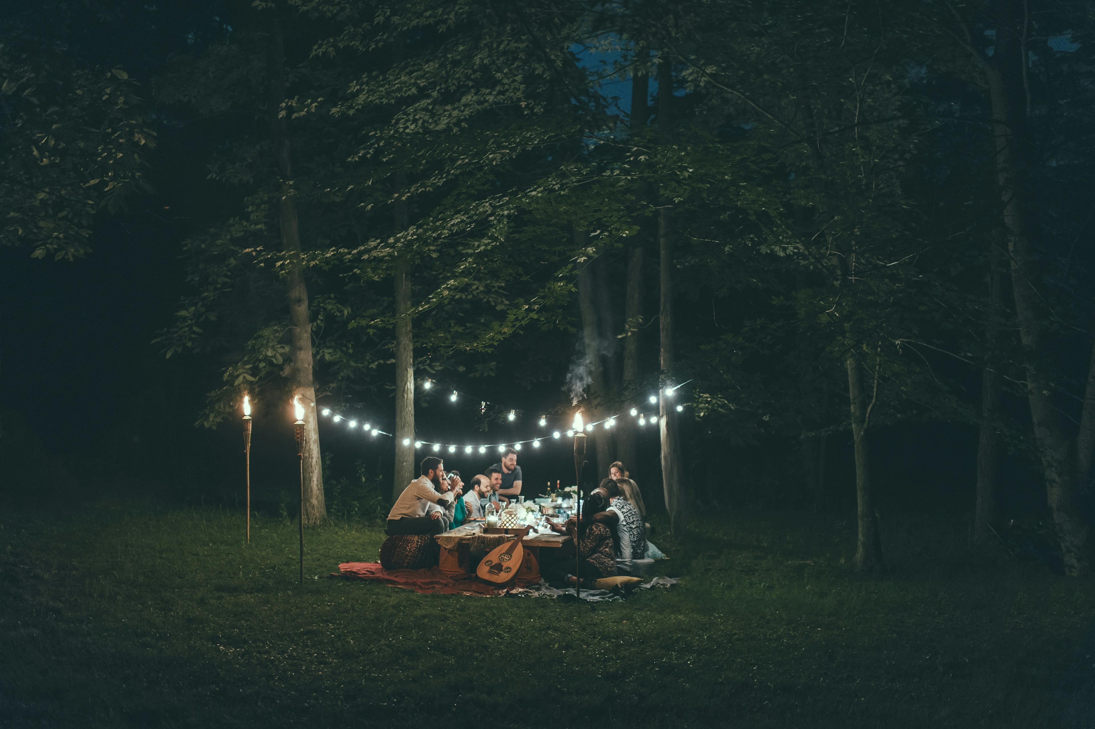 Festa num jardim com luzes suspensas à noite
