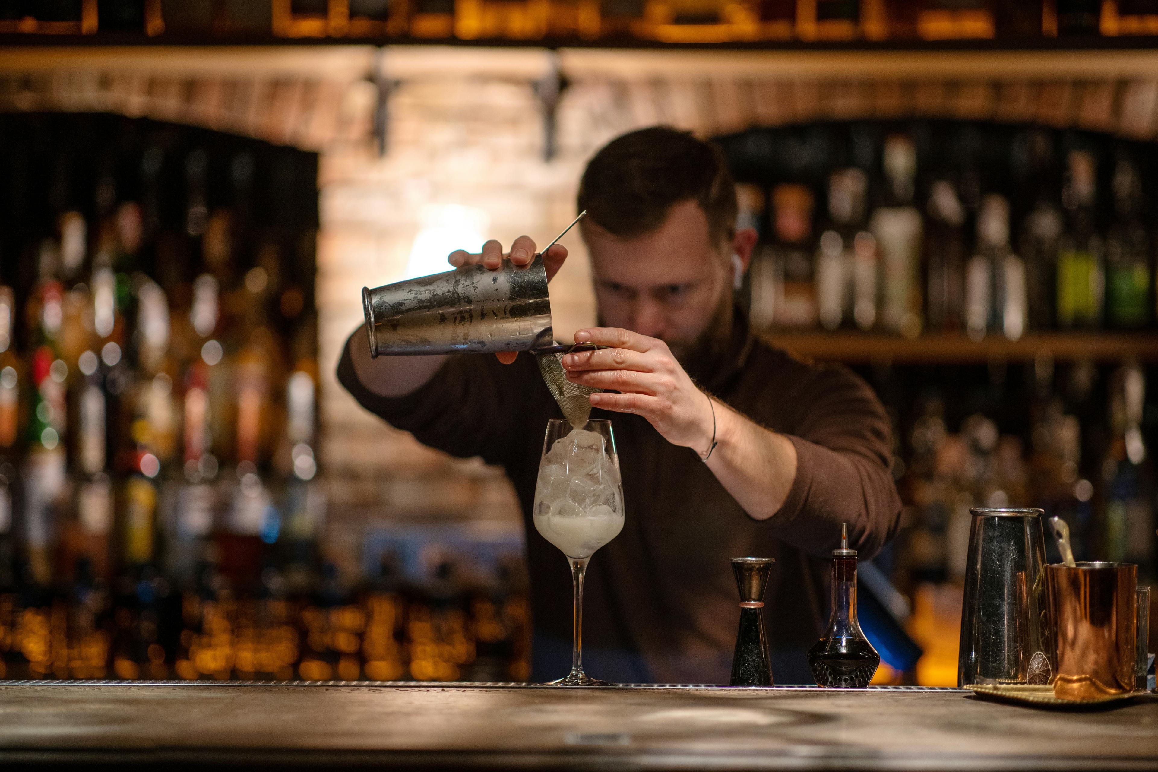 Bartender a preparar um cocktail ao balcão