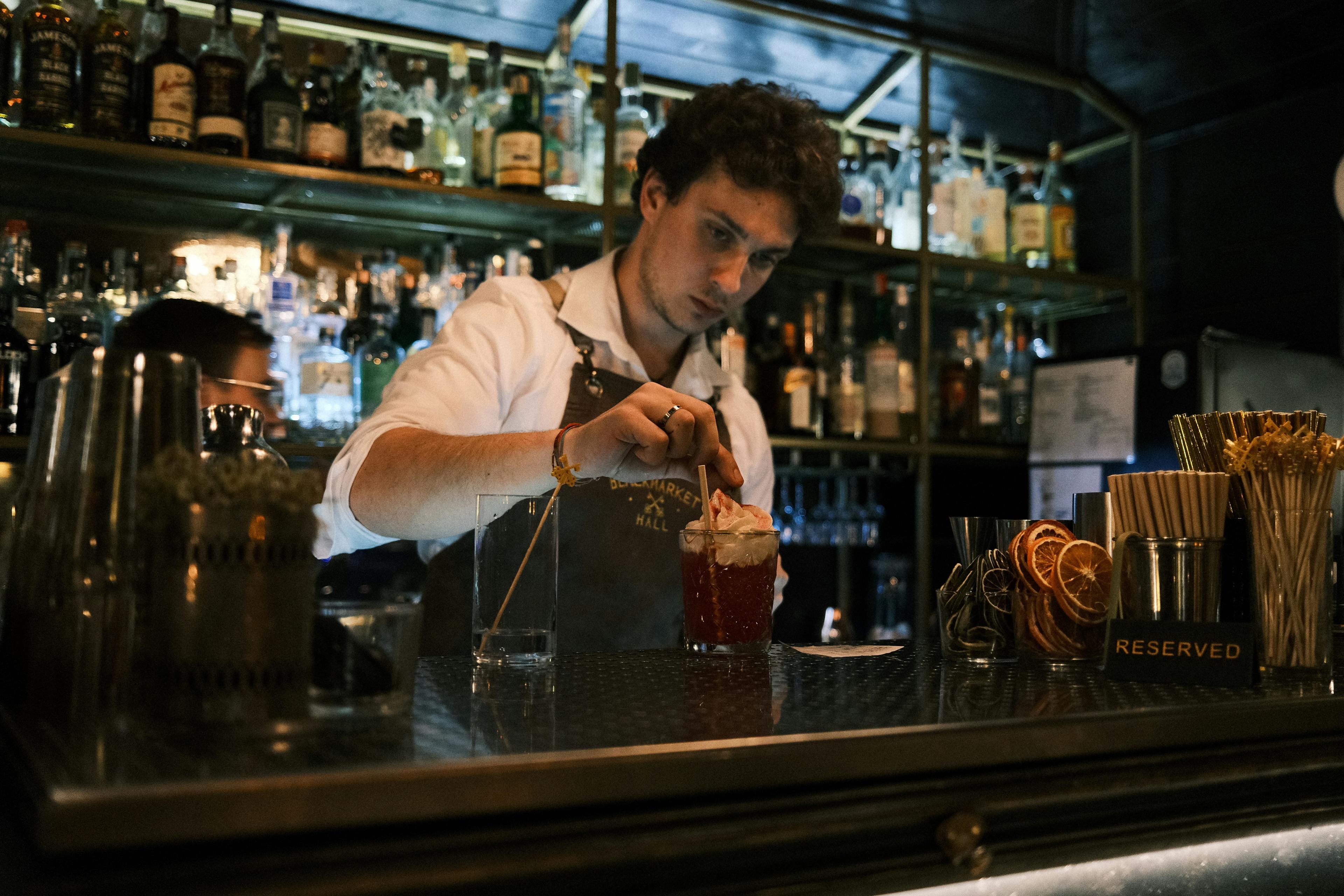 Bartender a preparar uma bebida atrás do balcão